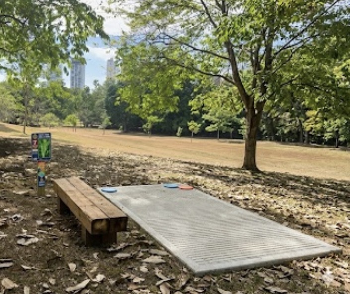 Ejemplo de tee box: pad de concreto, banca y señalización